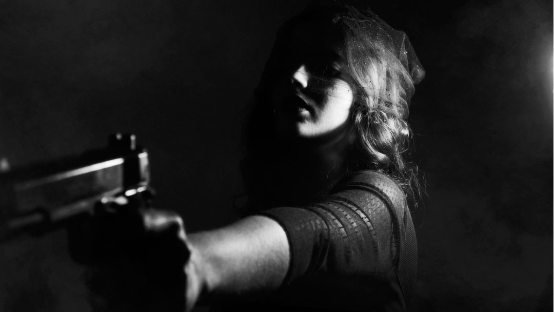 Photo of woman holding pistol in noir movie context