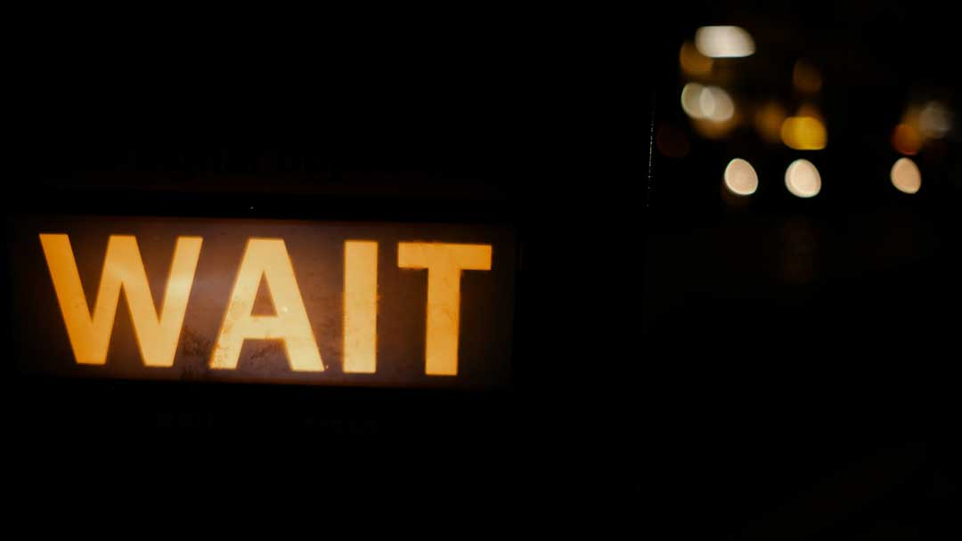 An image of a 'wait' neon sign, for the blog post "Step into the story: 5 powerful features of Immersive art."