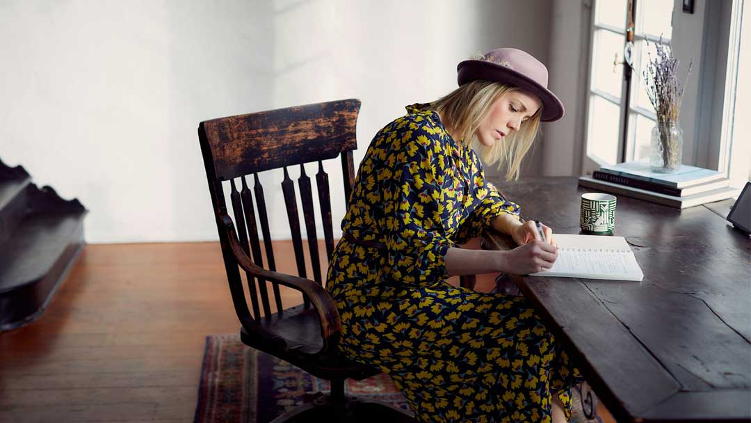 Photo of a woman writing by Darius Bashar on Unsplash