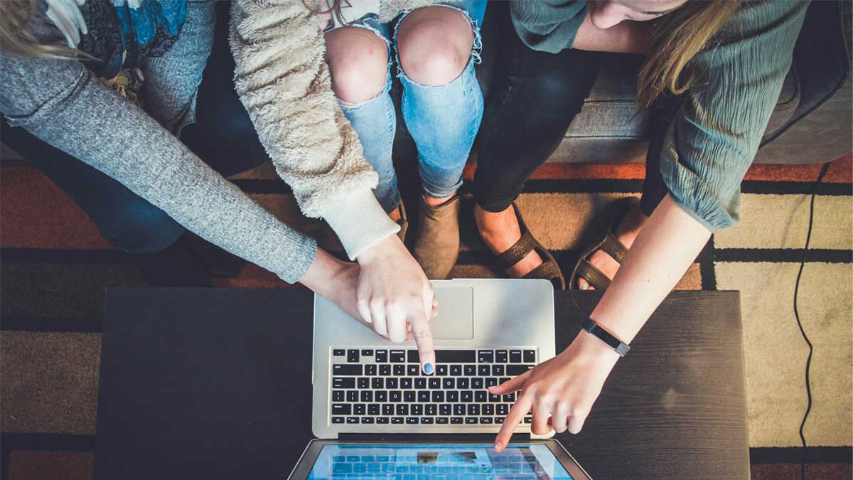 3PeoplePointing Image of 3 young people pointing at a laptop screen.