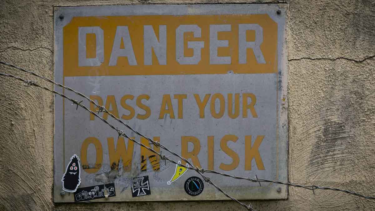Image of a sign reading "Danger Pass at your own risk."