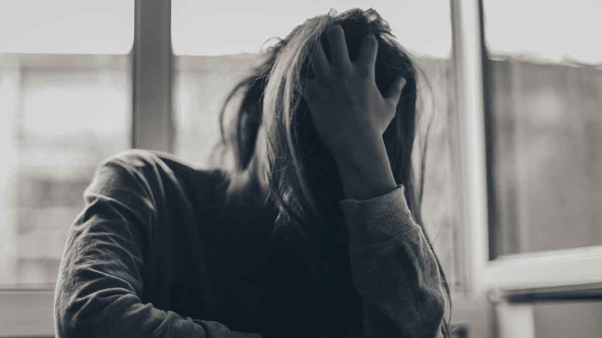 Image of a woman with her head in her hands.